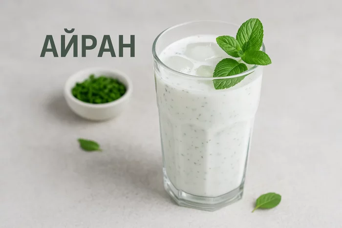 Айран со льдом и мятой в стакане, рядом миска с зеленью