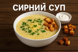 Сирний суп у тарілці з грінками і зеленню