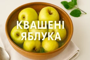 Квашені яблука в глиняній мисці з написом «Квашені яблука»